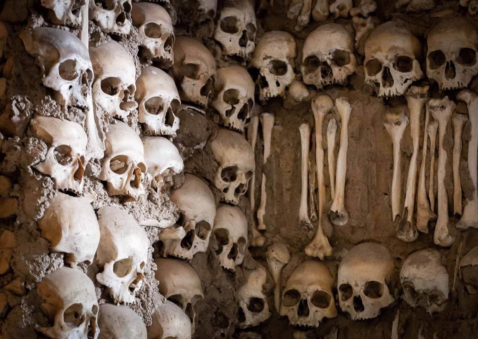Close-up of human skulls and bones covering the walls of Capela dos Ossos in Évora, Portugal, a famous dark tourism and dark history site.